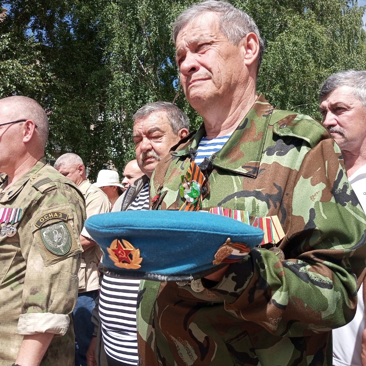 Флуз Рафкатович Нигаматьянов в форме с наградами держит в руках голубой берет ВДВ во время торжественного мероприятия, посвящённого памяти воинов-десантников. Рядом — боевые товарищи.