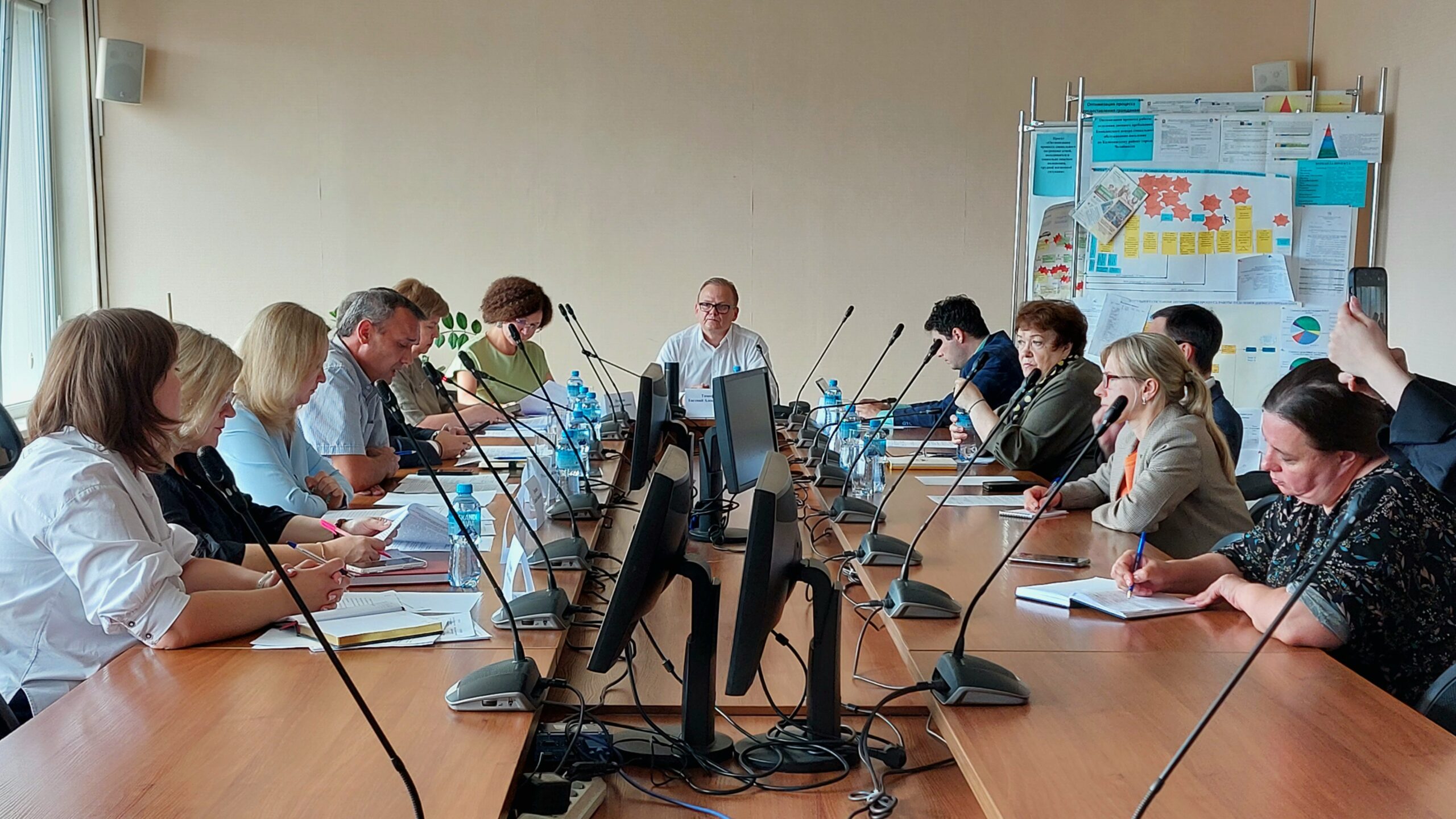 Общий вид заседания Общественного совета при Министерстве социальных отношений: за длинным столом работают члены совета и приглашённые эксперты.