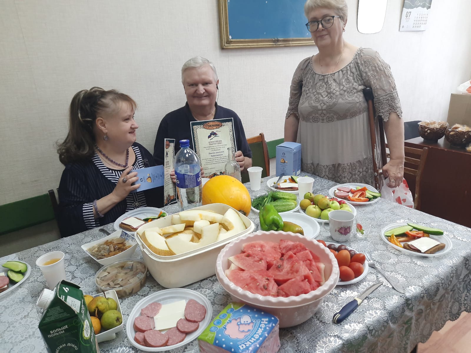 о время чаепития Татьяна Попкова вручает грамоты за активное участие. На столе — щедрые дары лета