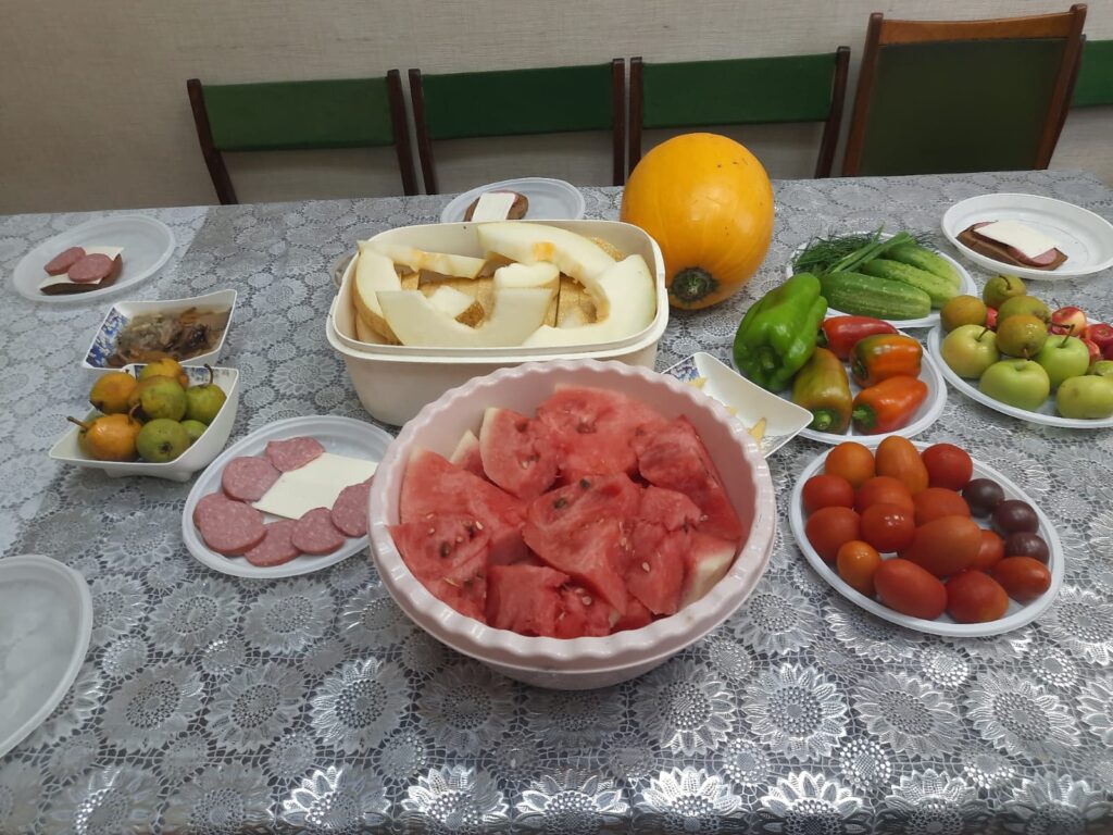 Арбуз, дыня, фрукты, овощи, закуски — угощение для участников встречи, собравшихся в тёплой и душевной обстановке