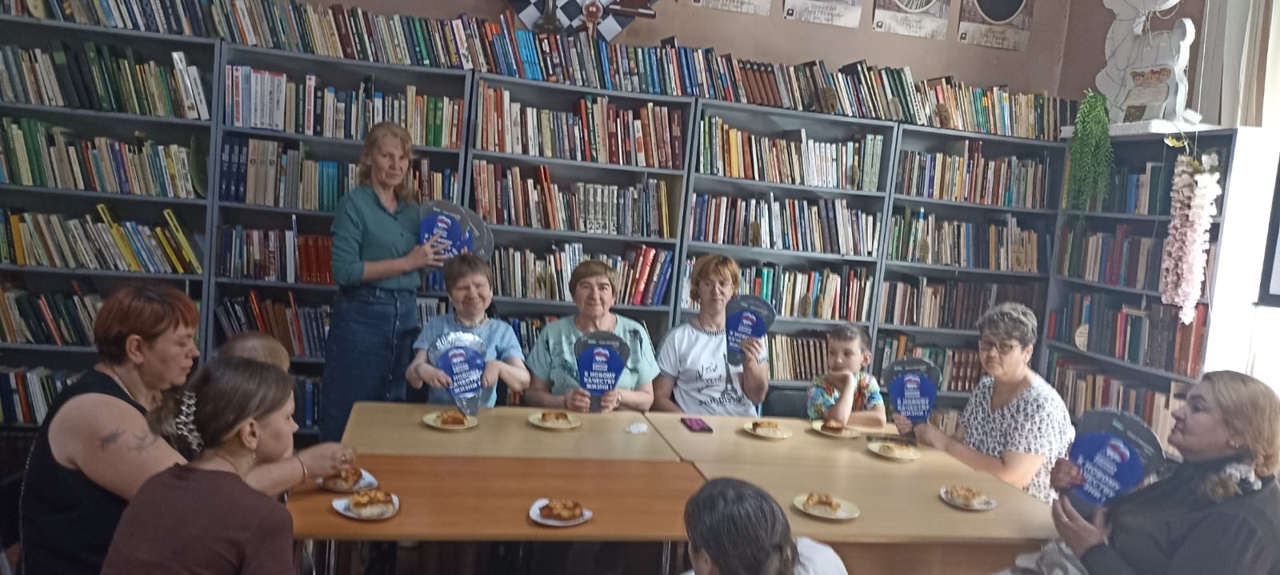 После игры участники за чаепитием. На столах угощение, победители держат подарки — сервировочные блюда от спонсоров.