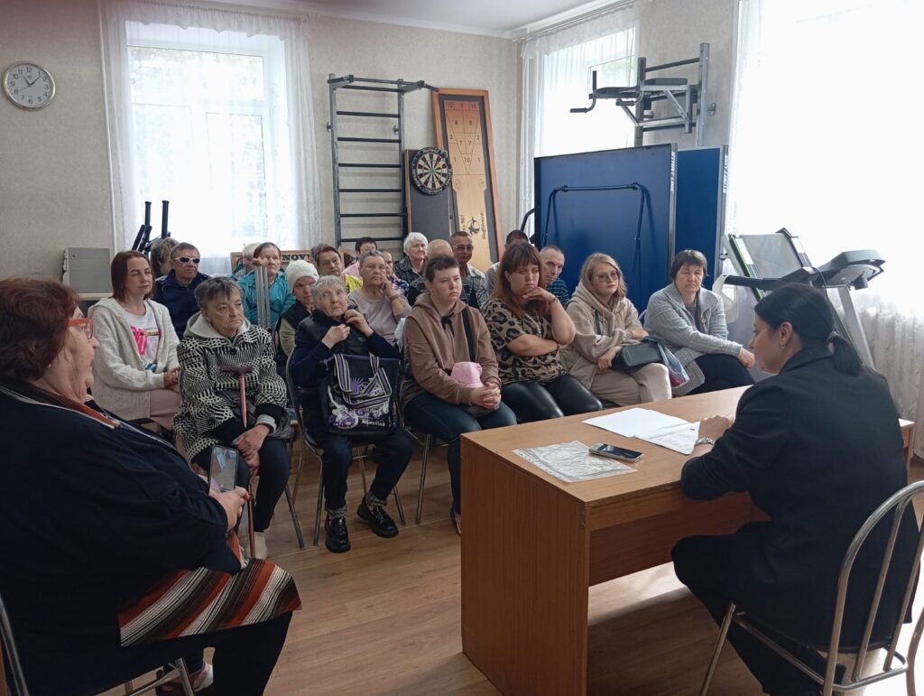 Члены Верхнеуфалейской МО ВОС собрались на встречу. Они внимательно слушающие выступление приглашённого специалиста за столом.