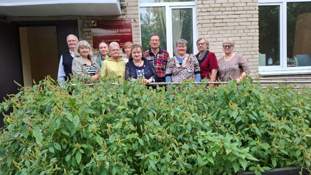 участники мероприятия позируют на память у входа в здание Совета ветеранов.