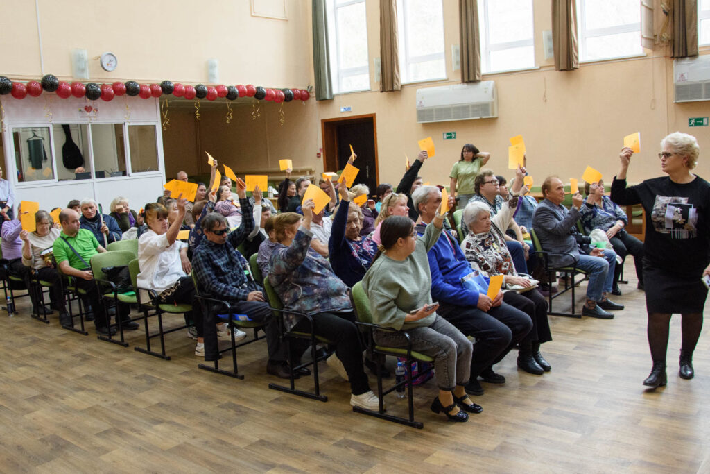 делегаты конференции голосуют подняв вверх желтые бюллетени