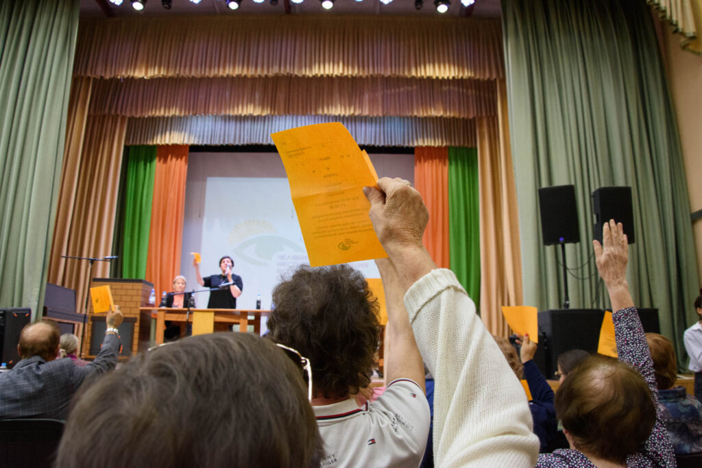 в руке желтый бюллетень поднятый вверх