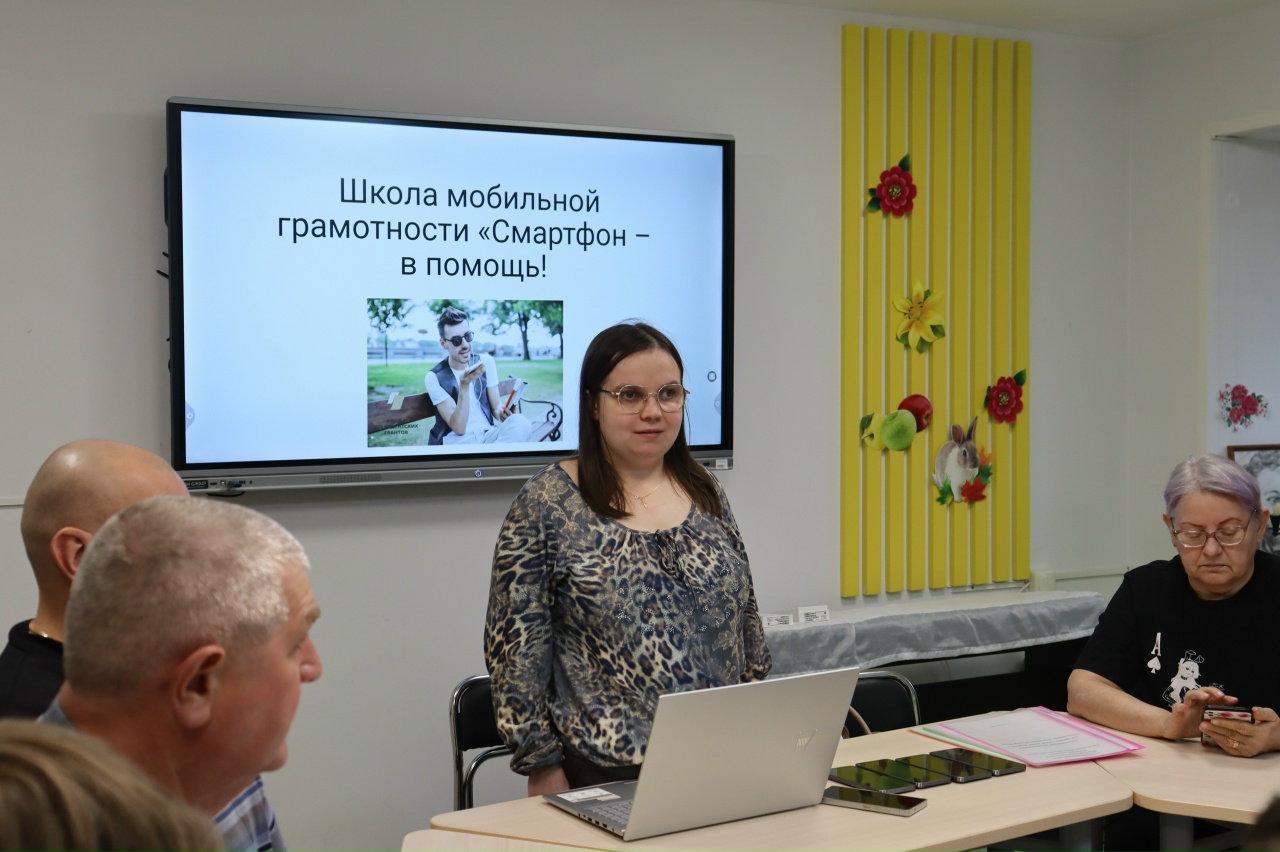 евгения боровикова сидит за столом и рассказывает о полезных функциях смартфона