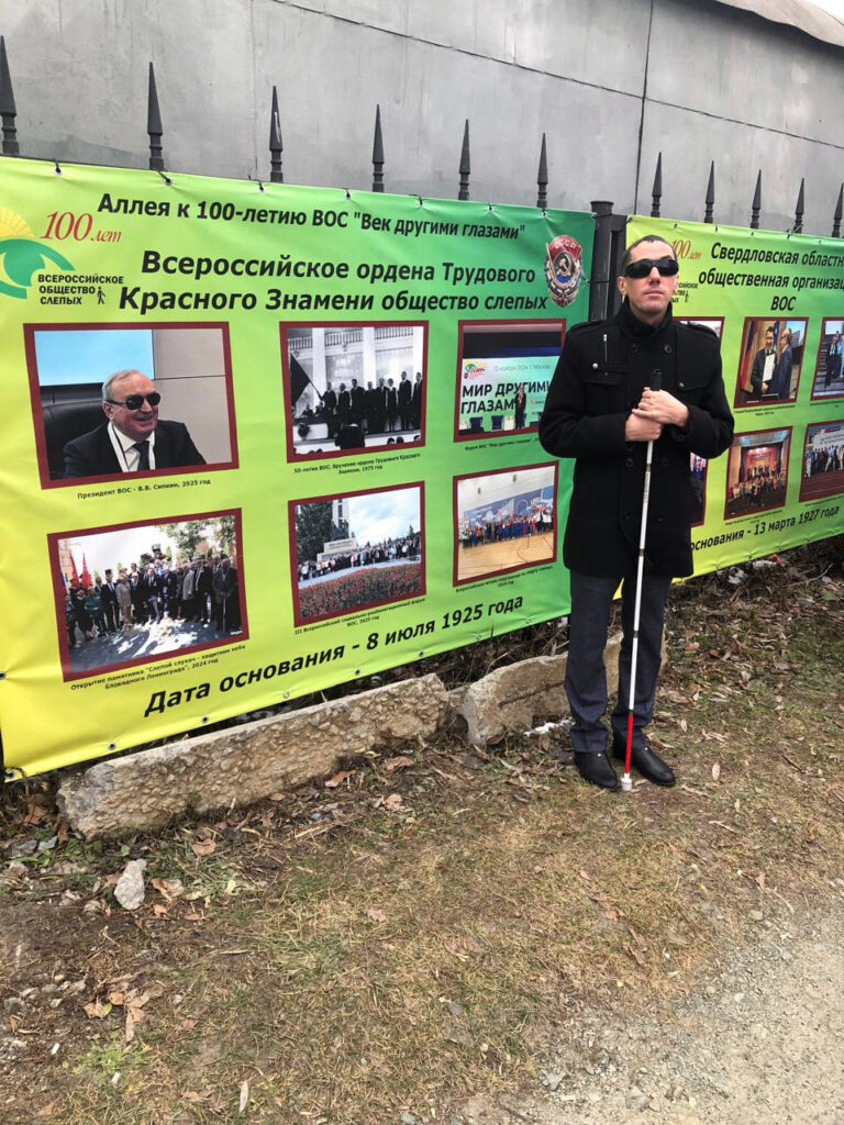 александр рожков у аллеи славы. на заднем фоне фотографии об истории вос