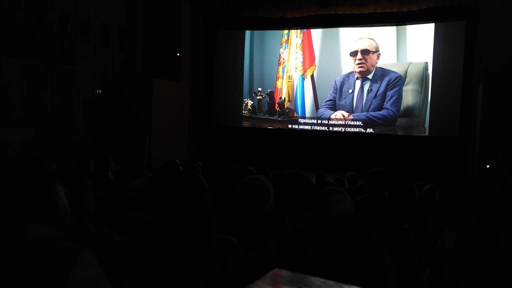 кадр из фильма. На экране президент вос владимир сипкин