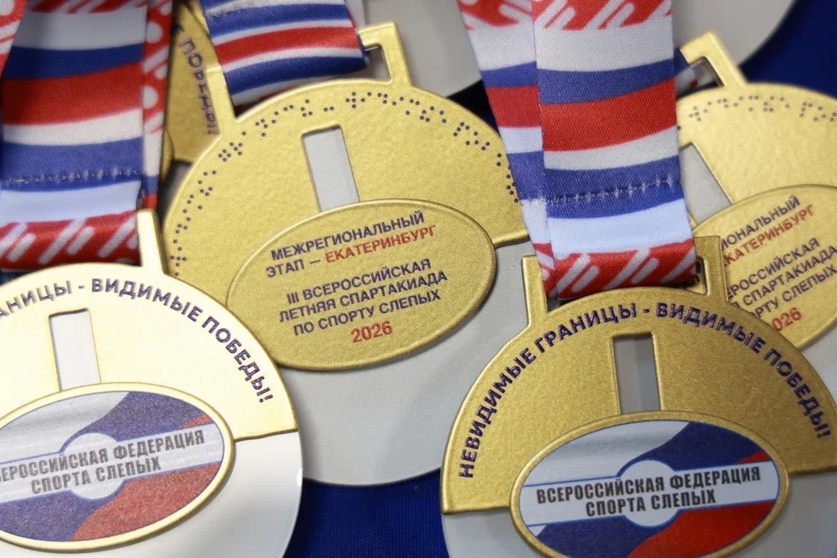 На фото несколько золотисто-белых медалей на лентах цветов флага России. Надпись: «НЕВИДИМЫЕ ГРАНИЦЫ – ВИДИМЫЕ ПОБЕДЫ!» и «ВСЕРОССИЙСКАЯ ФЕДЕРАЦИЯ СПОРТА СЛЕПЫХ». Центральная медаль: «Межрегиональный этап – Екатеринбург. Третья Всероссийская летняя спартакиада по спорту слепых. 2026».