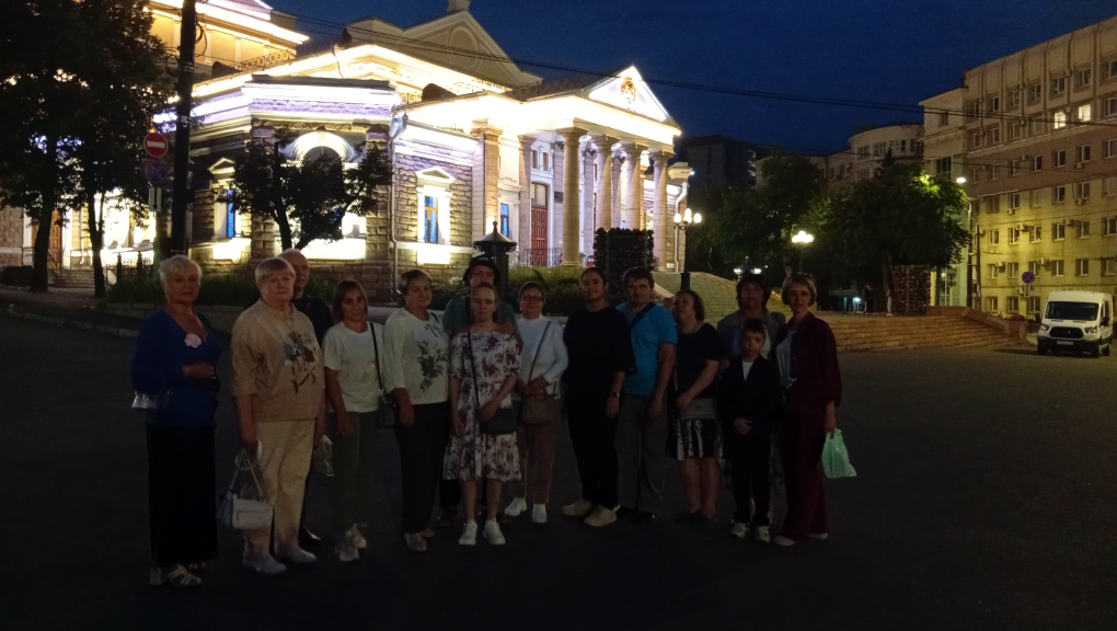 Участники поездки фотографируются вечером на улице у здания Челябинского молодёжного театра после спектакля.