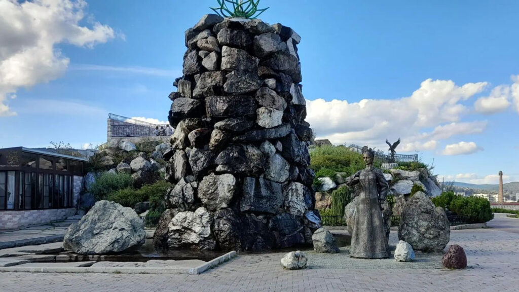 Каменная композиция и скульптура в парке имени Павла Бажова на фоне голубого неба.