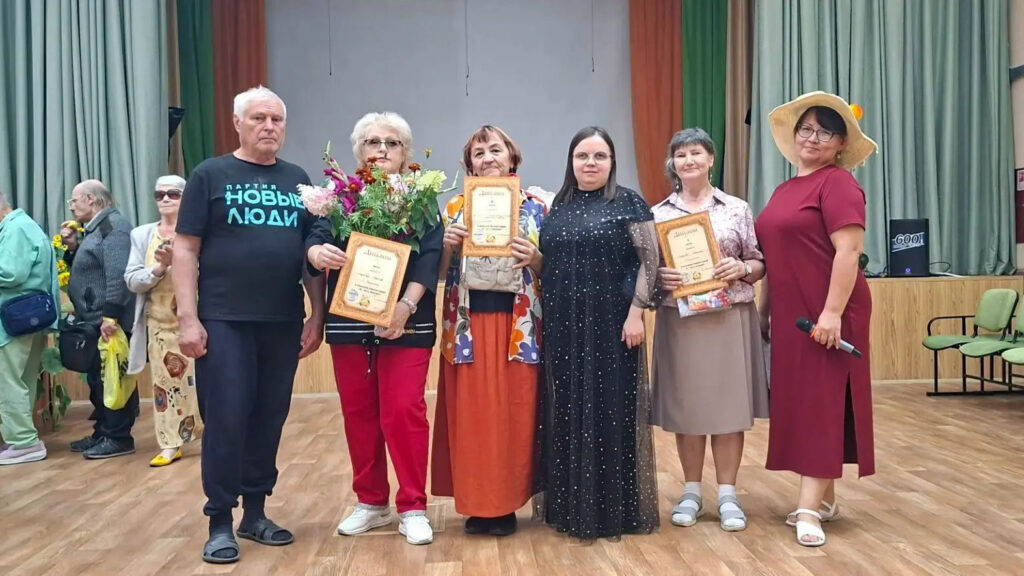 Победители конкурса фотографируются на сцене с дипломами и цветами.