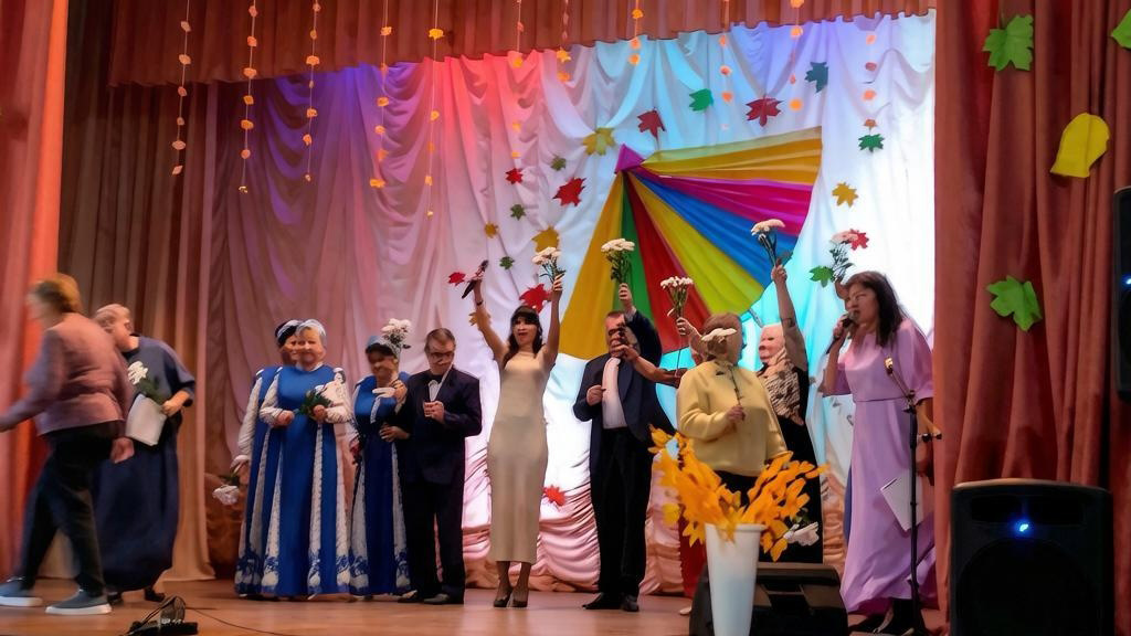 Участники концерта выходят на сцену с цветами под аплодисменты зрителей.