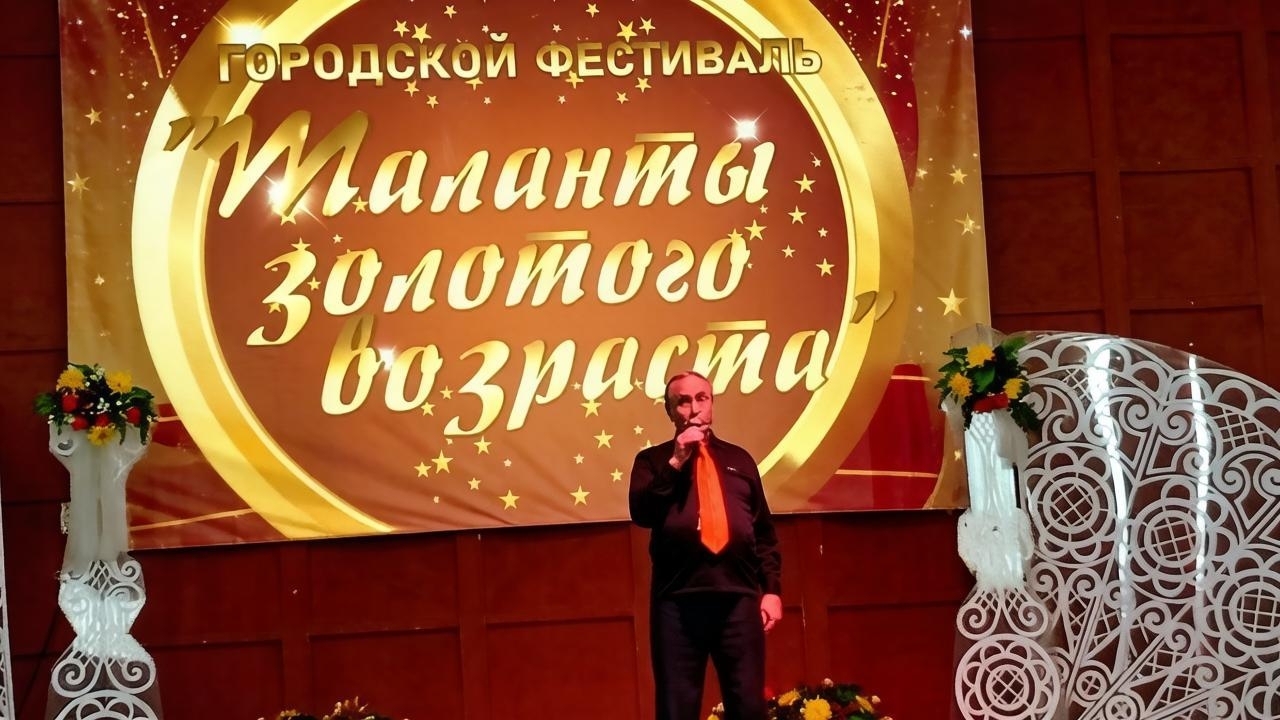 Мужчина выступает с песней на сцене фестиваля «Таланты золотого возраста».